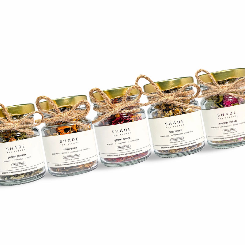 Row of small jars of Shade Botanicals Tea Blend on a white background