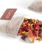 Shade Botanicals Golden Rosella loose leaf tea slightly spilled from a small tea pack
