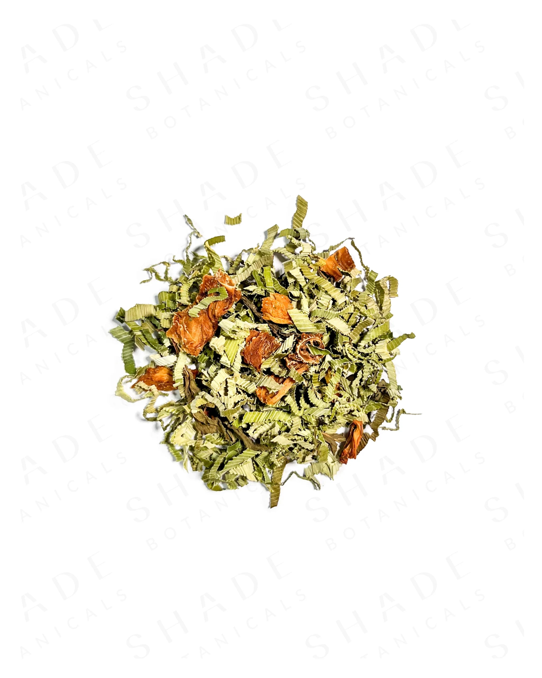 Dry green tea leaves with orange pieces on a white background